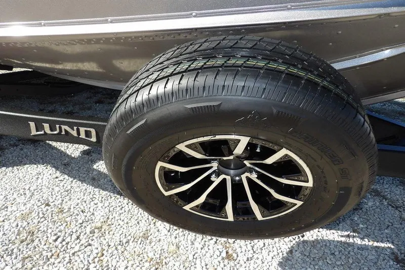 Slide: The Image of 2026 Lund 2075 Impact XS trailer tire on gravel surface. - 52