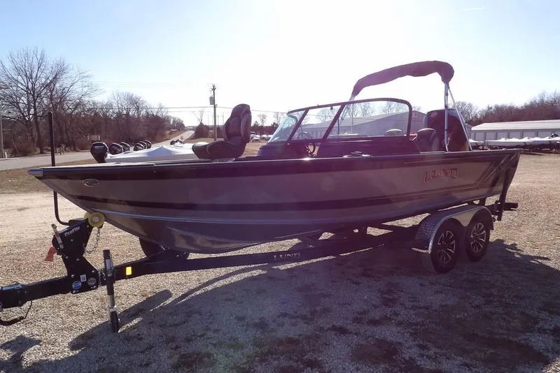 Slide: The Image of 2026 Lund 2075 Impact XS boat on trailer, parked outdoors on gravel. - 7