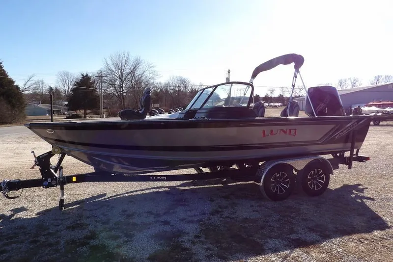 Slide: The Image of 2026 Lund 2075 Impact XS boat on trailer, parked outdoors in sunny setting. - 9