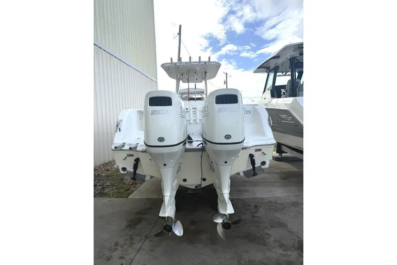 Slide: The Image of 2009 Atlantic 275 CC boat with twin 200 HP outboard engines, docked outdoors. - 2