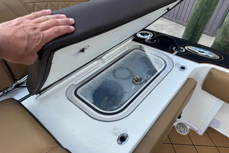 Slide: The Image of 2020 Fountain 38 Center Console boat with open storage compartment and hand resting on seat. - 11