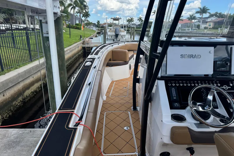Slide: The Image of 2020 Fountain 38 Center Console boat docked, featuring Simrad navigation system and luxurious seating. - 16