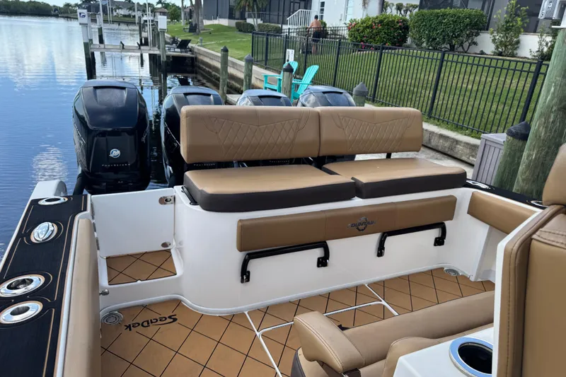Slide: The Image of 2020 Fountain 38 Center Console boat with tan seating and triple outboard engines. - 9
