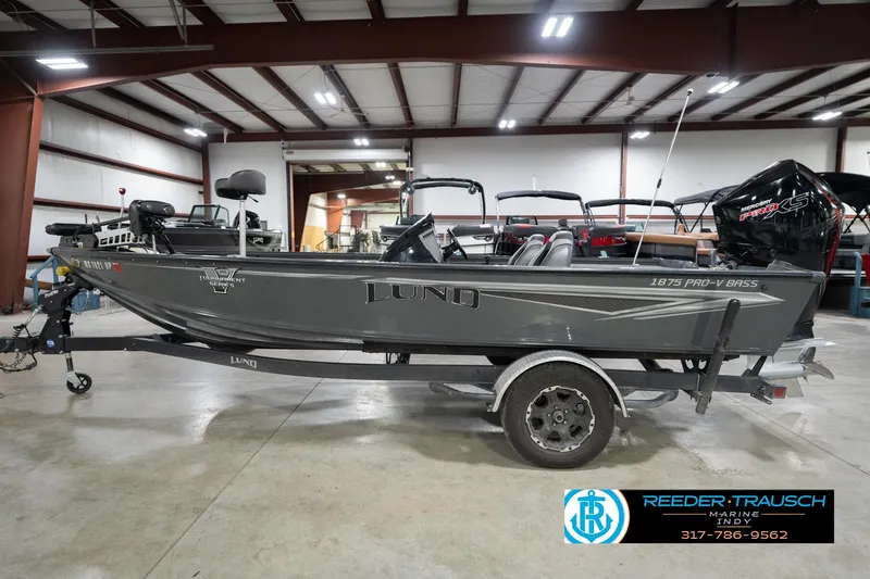 Slide: The Image of 2020 Lund 1875 Pro-V Bass boat in a showroom, featuring a sleek gray design. - 10
