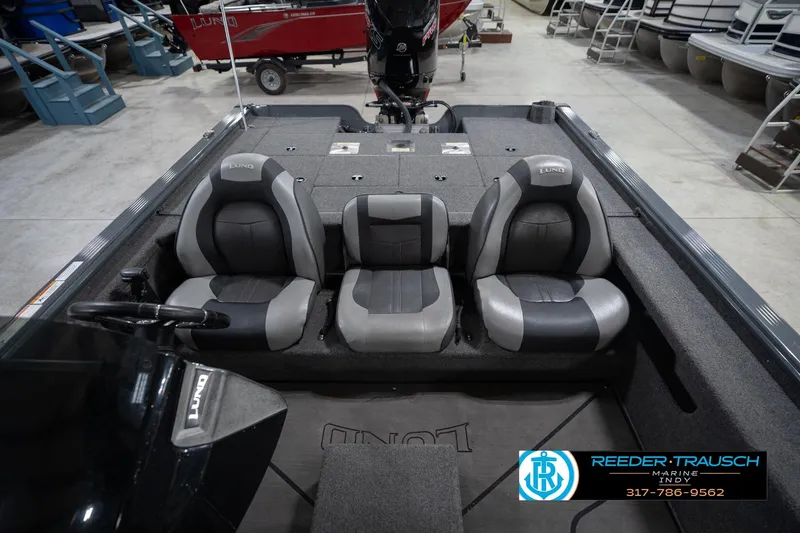 Slide: The Image of 2020 Lund 1875 Pro-V Bass boat interior with three gray and black seats in showroom. - 19