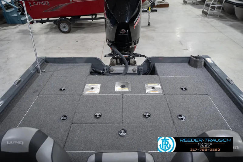 Slide: The Image of 2020 Lund 1875 Pro-V Bass boat interior with motor, carpeted deck, and seating. - 20