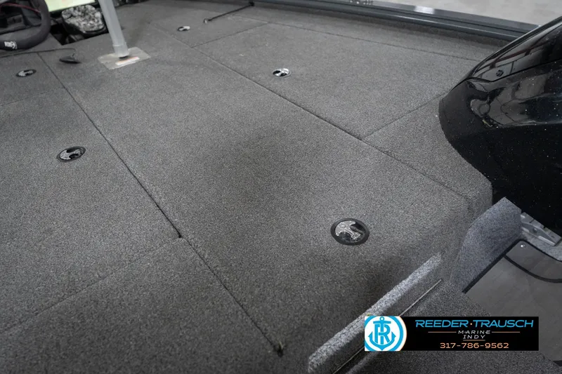 Slide: The Image of 2020 Lund 1875 Pro-V Bass boat deck with carpeted surface and storage compartments. - 23