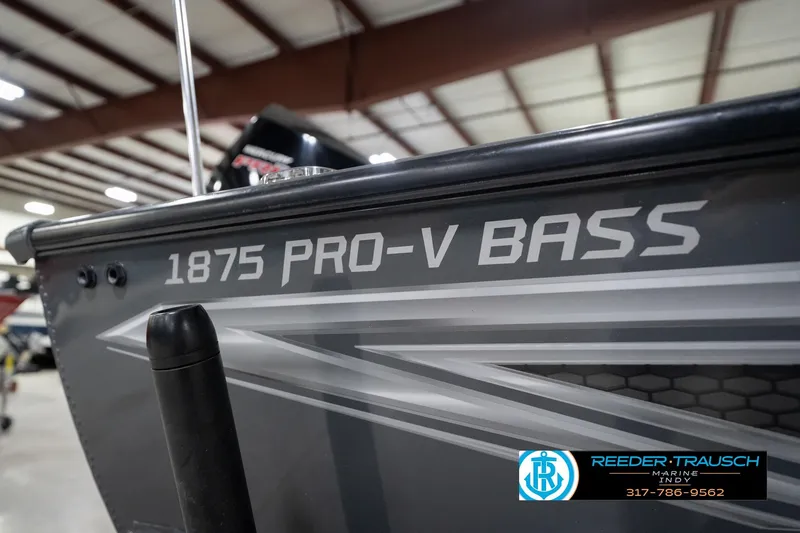 Slide: The Image of 2020 Lund 1875 Pro-V Bass boat in showroom, featuring sleek design and branding. - 54
