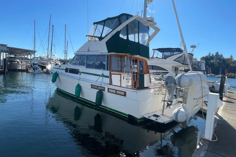 The Image of 1989 Bayliner 3888 Motoryacht docked at a marina, surrounded by other boats. - 0