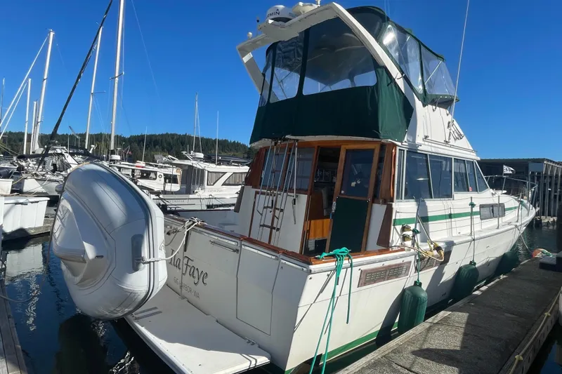 Slide: The Image of 1989 Bayliner 3888 Motoryacht docked at marina, featuring green canopy and inflatable dinghy. - 1