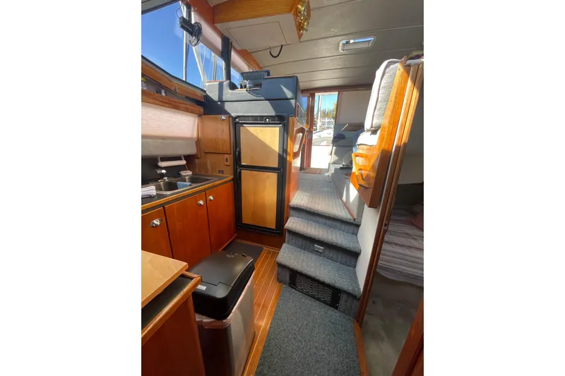 Slide: The Image of Interior of 1988 Bayliner 3888 Motoryacht, featuring kitchen and carpeted stairs. - 14