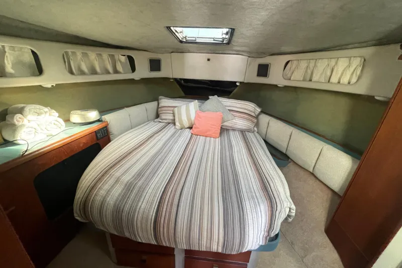 Slide: The Image of Cozy bedroom interior of 1988 Bayliner 3888 Motoryacht with striped bedding and soft lighting. - 15