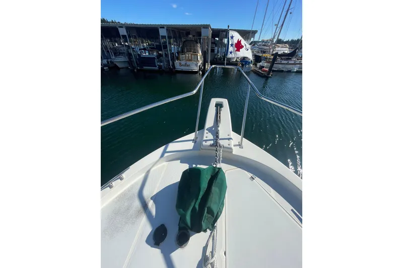 Slide: The Image of 1988 Bayliner 3888 Motoryacht bow view at marina, clear sky, calm water. - 26