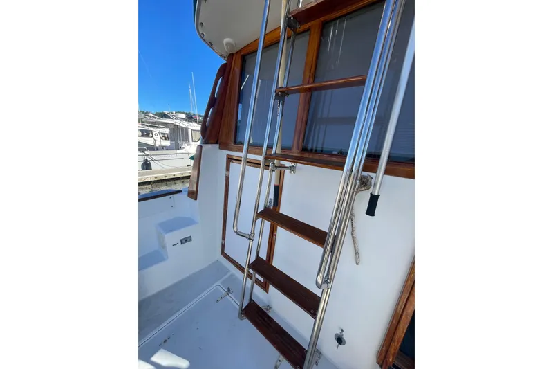Slide: The Image of 1988 Bayliner 3888 Motoryacht ladder and deck area with wooden accents. - 3