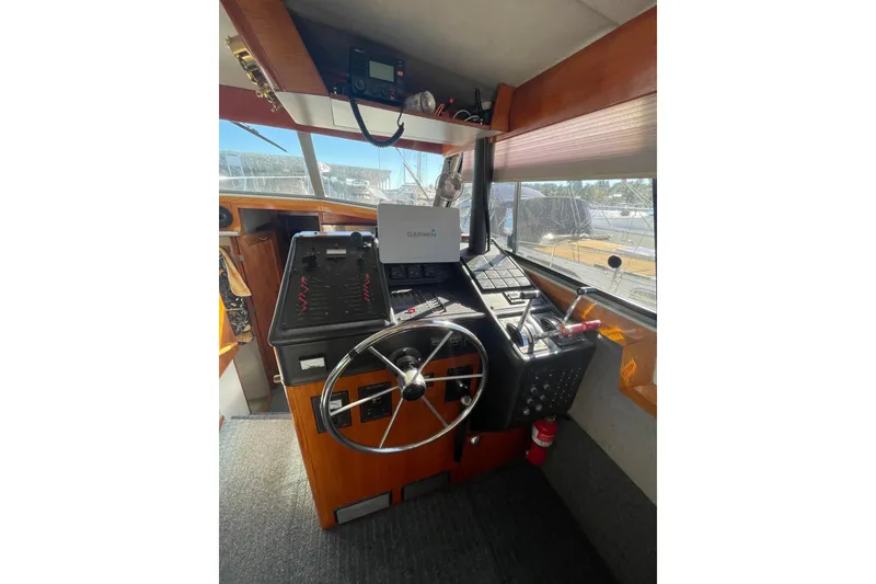 Slide: The Image of 1988 Bayliner 3888 Motoryacht helm with steering wheel, navigation equipment, and control panel. - 9