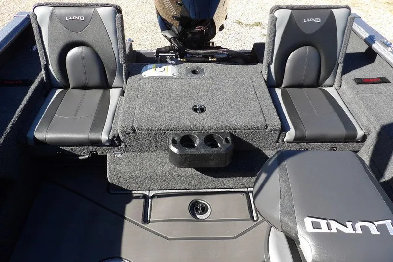 Slide: The Image of 2026 Lund 2075 Impact XS boat interior with gray seating and storage compartments. - 11