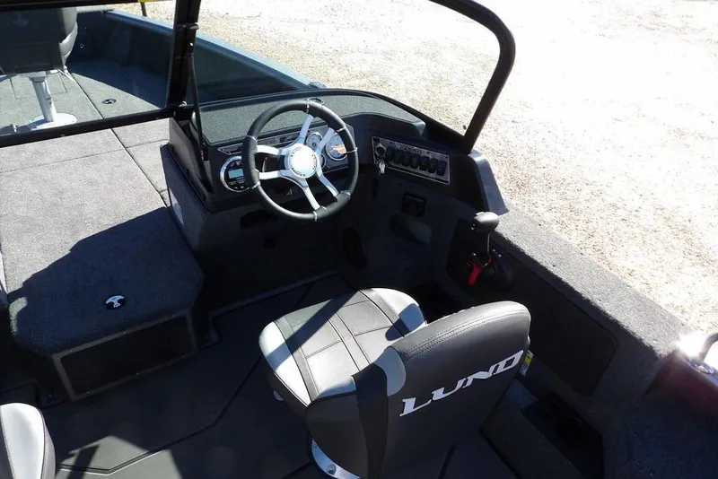 Slide: The Image of 2026 Lund 2075 Impact XS boat interior with steering wheel and seating. - 18