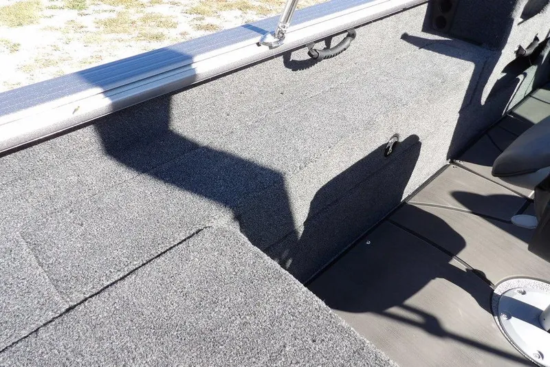 Slide: The Image of 2026 Lund 2075 Impact XS boat interior with gray carpet and seating area. - 19