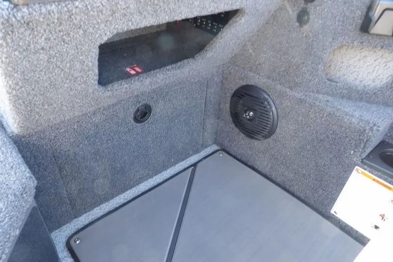 Slide: The Image of Interior of 2026 Lund 2075 Impact XS boat, featuring carpeted storage and speaker. - 27