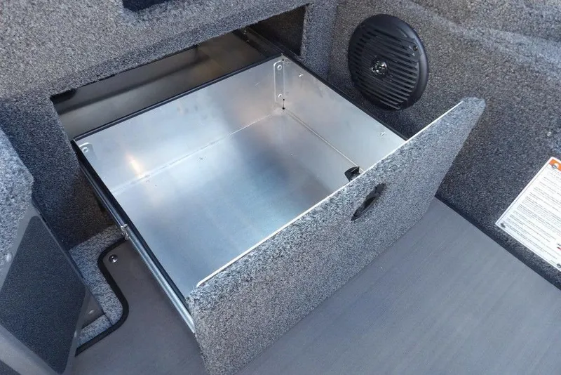 Slide: The Image of 2026 Lund 2075 Impact XS boat storage compartment with open drawer and speaker. - 28