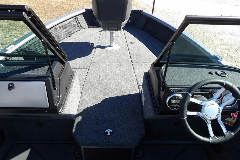 Slide: The Image of 2026 Lund 2075 Impact XS boat interior with steering wheel and seating area. - 40