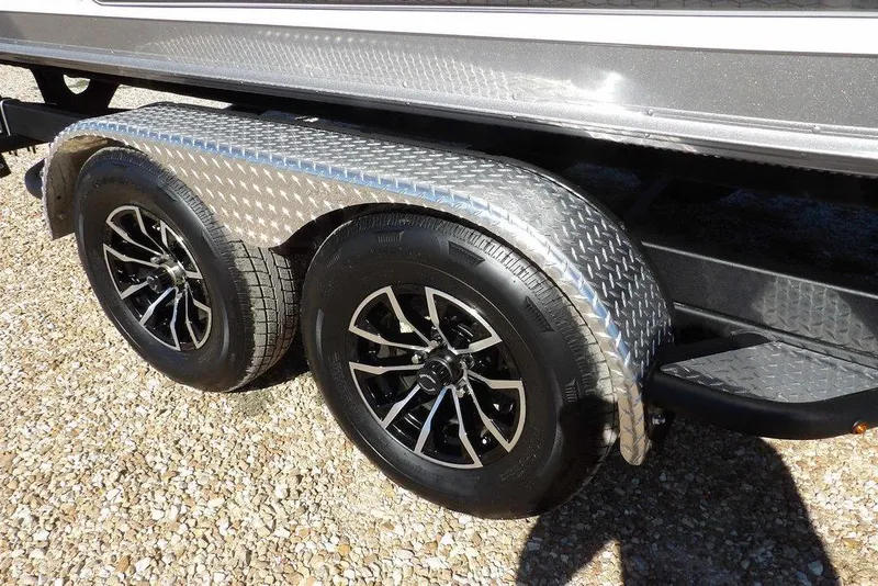 Slide: The Image of 2026 Lund 2075 Impact XS trailer with dual black alloy wheels on gravel. - 51