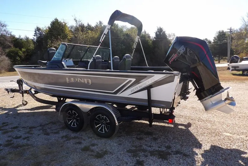 Slide: The Image of 2026 Lund 2075 Impact XS boat on trailer, featuring sleek design and powerful engine. - 6