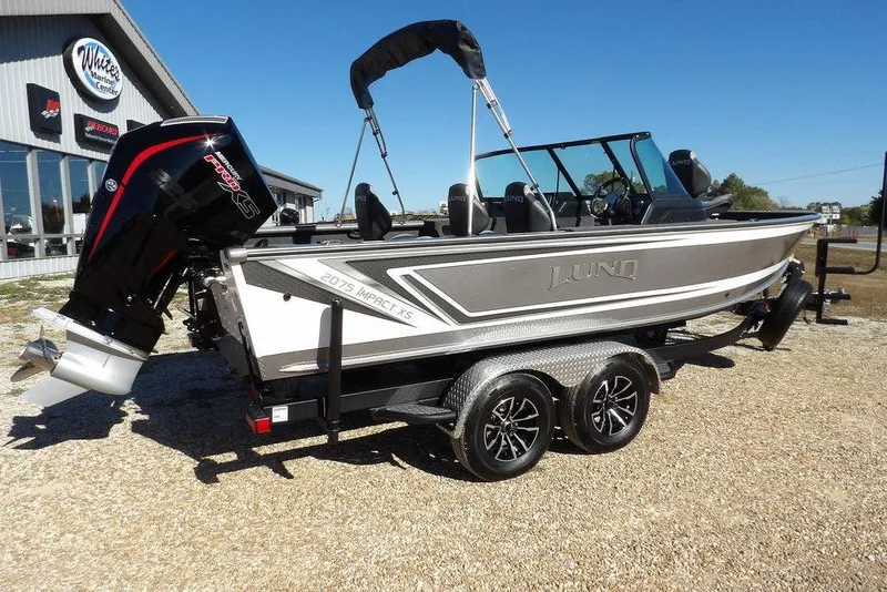Slide: The Image of 2026 Lund 2075 Impact XS boat on trailer, displayed outdoors at a marine center. - 7