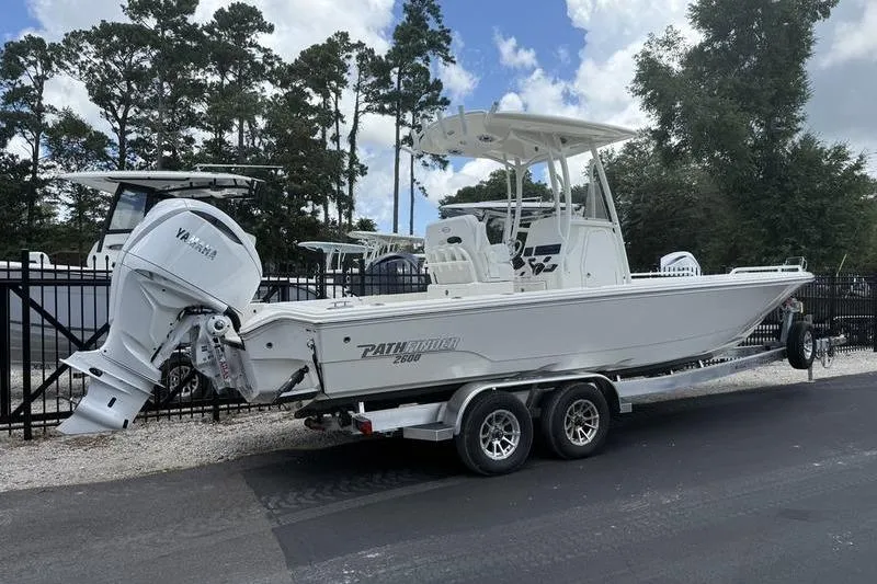 Slide: The Image of 2025 Pathfinder 2600 TRS boat on trailer, parked outdoors, with Yamaha engine. - 2