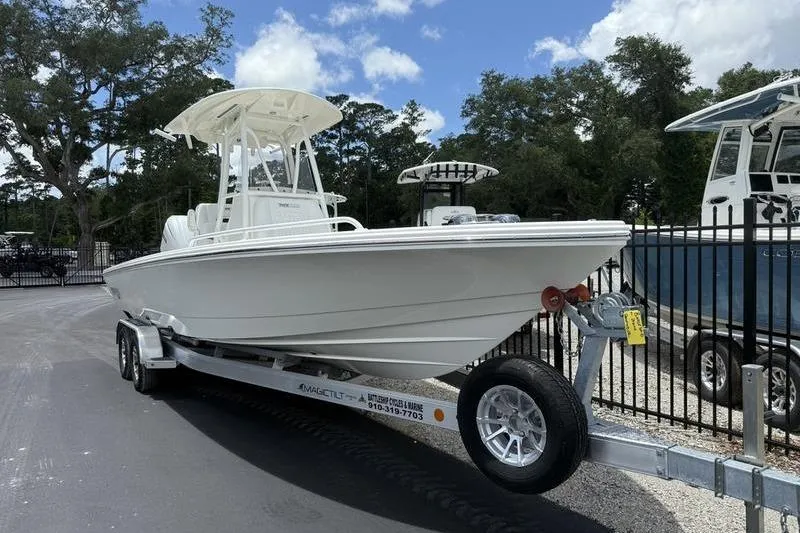 Slide: The Image of 2025 Pathfinder 2600 TRS boat on trailer, parked outdoors under a clear sky. - 3