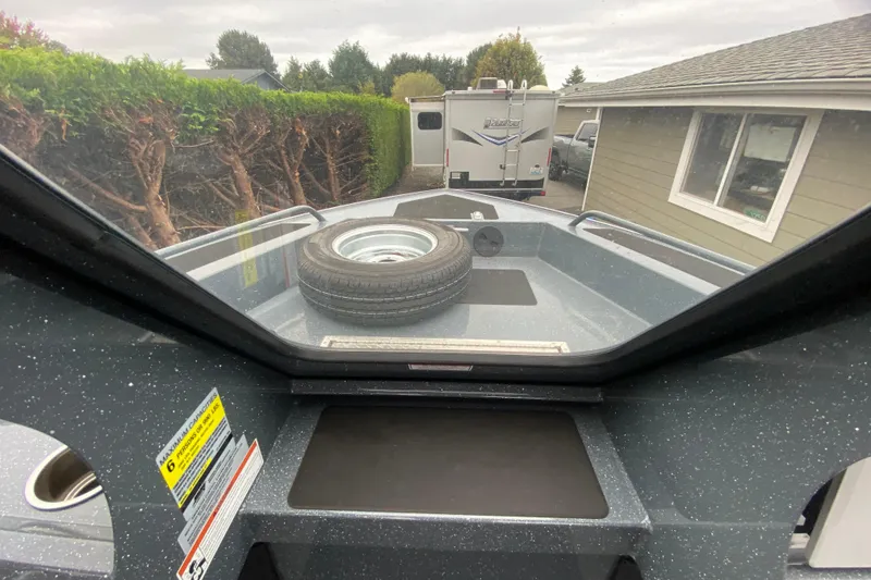 Slide: The Image of 2022 Duckworth 20XT Advantage boat with spare tire on deck, parked near RV and house. - 12