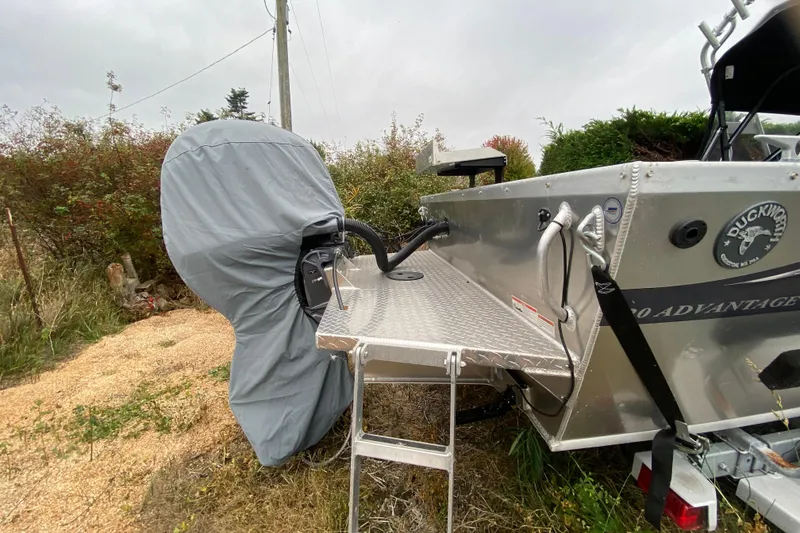 Slide: The Image of 2022 Duckworth 20XT Advantage boat with covered motor and aluminum deck in outdoor setting. - 21