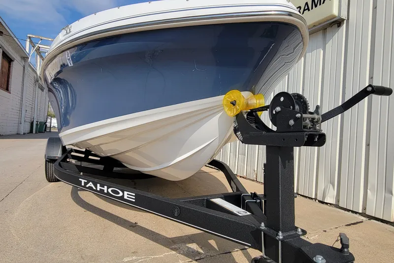 Slide: The Image of 2022 Tahoe 185 S WT boat on trailer, parked outdoors near a building. - 16