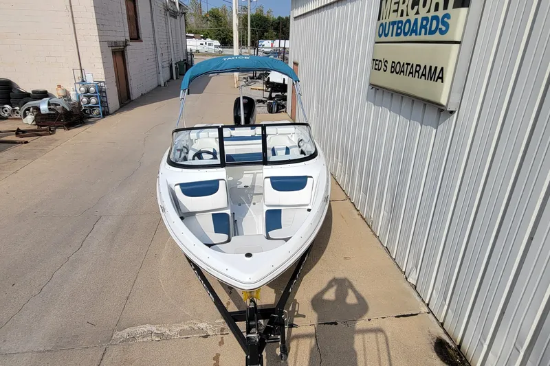Slide: The Image of 2022 Tahoe 185 S WT boat with blue canopy parked outside a dealership. - 3