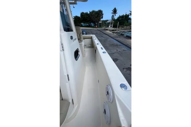 Slide: The Image of 2015 Pursuit C 260 Center Console boat docked, showcasing side view and seating area. - 12