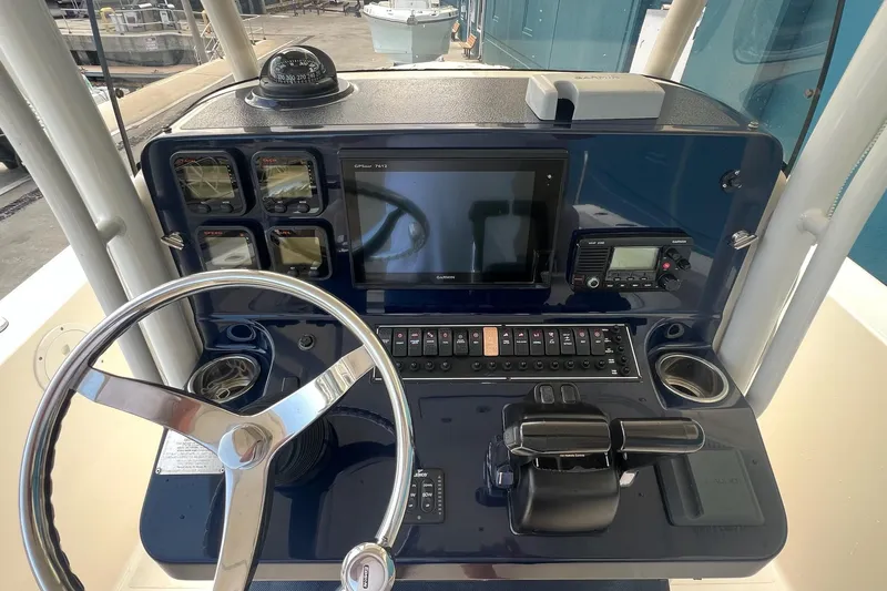 Slide: The Image of 2015 Pursuit C 260 Center Console boat dashboard with steering wheel and navigation controls. - 14