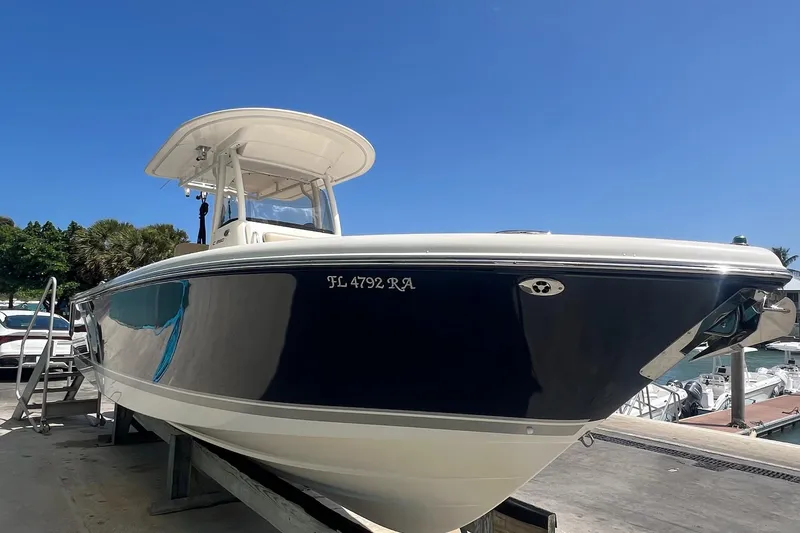 Slide: The Image of 2015 Pursuit C 260 Center Console boat on a dock under clear blue sky. - 2