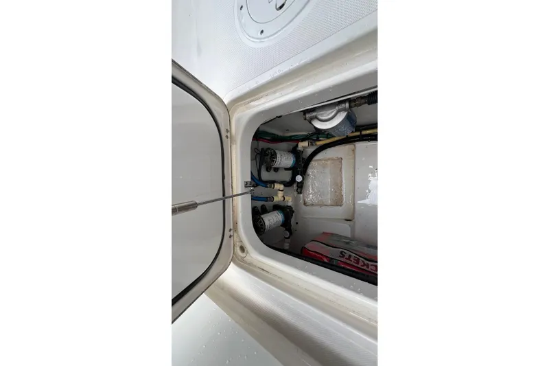 Slide: The Image of 2015 Pursuit C 260 Center Console storage compartment with equipment and wiring. - 20