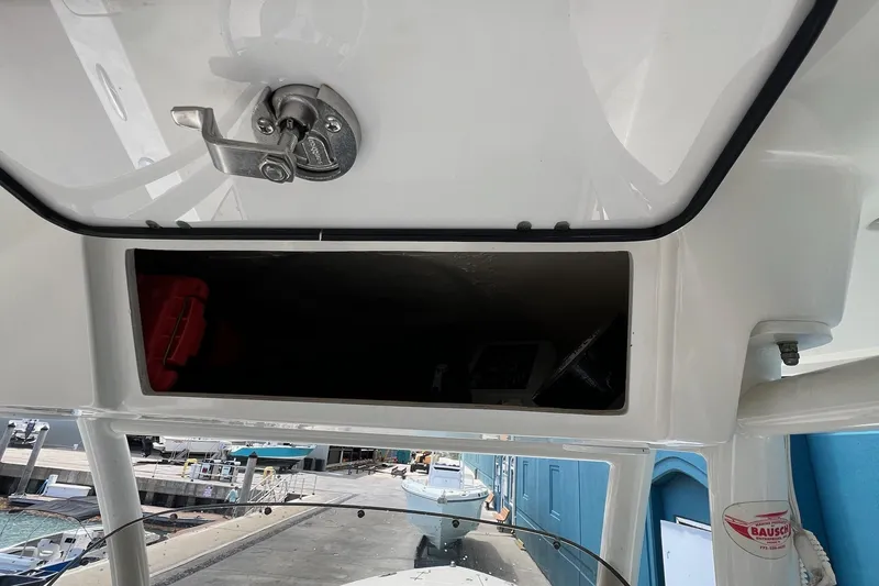 Slide: The Image of 2015 Pursuit C 260 Center Console boat storage compartment with latch, dockside view. - 22