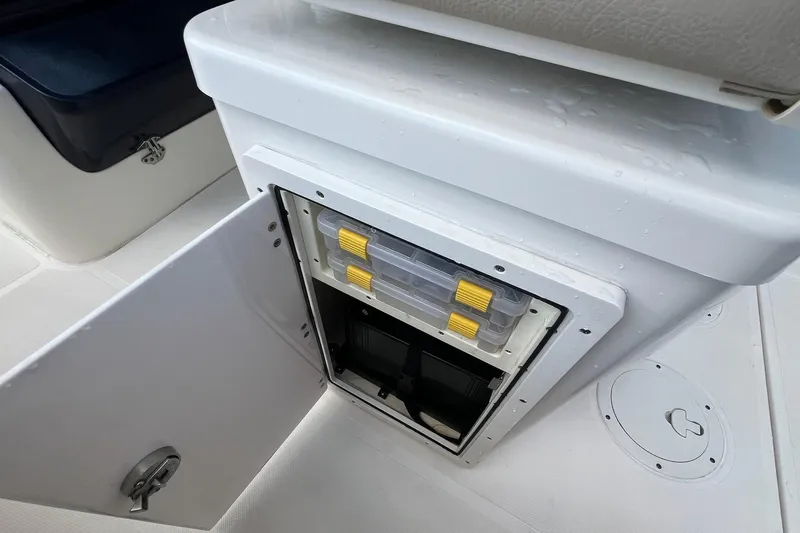 Slide: The Image of 2015 Pursuit C 260 Center Console storage compartment with open door and organized containers. - 25