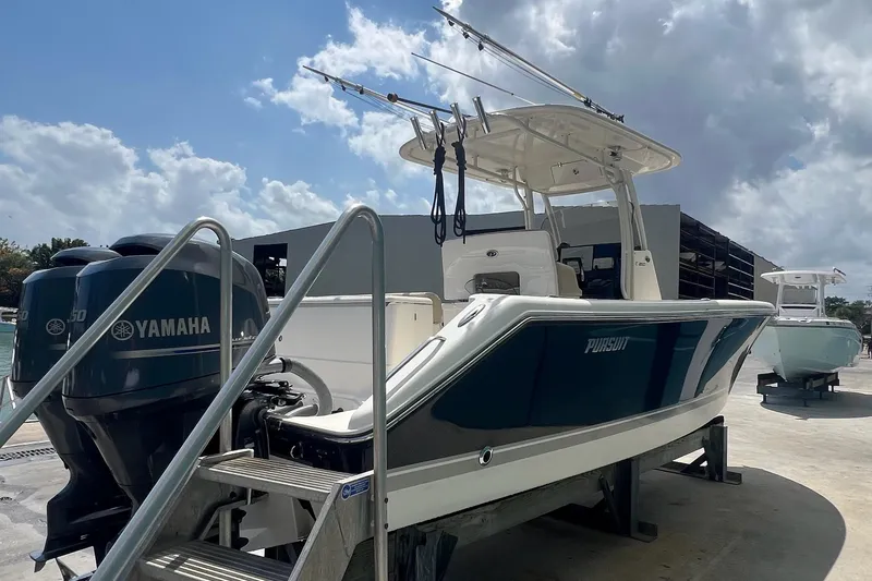 Slide: The Image of 2015 Pursuit C 260 Center Console boat with Yamaha engines, docked under a cloudy sky. - 3