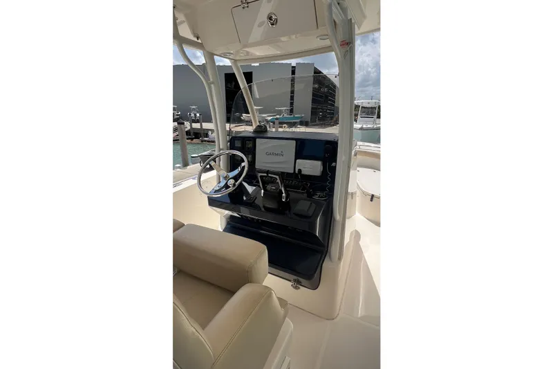 Slide: The Image of 2015 Pursuit C 260 Center Console boat interior with steering wheel and Garmin display. - 5