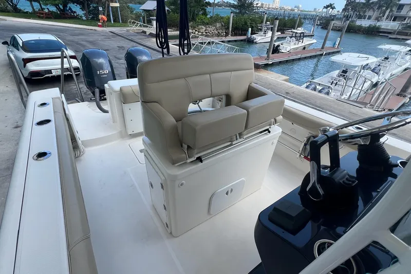 Slide: The Image of 2015 Pursuit C 260 Center Console boat interior with dual engines and waterfront view. - 6