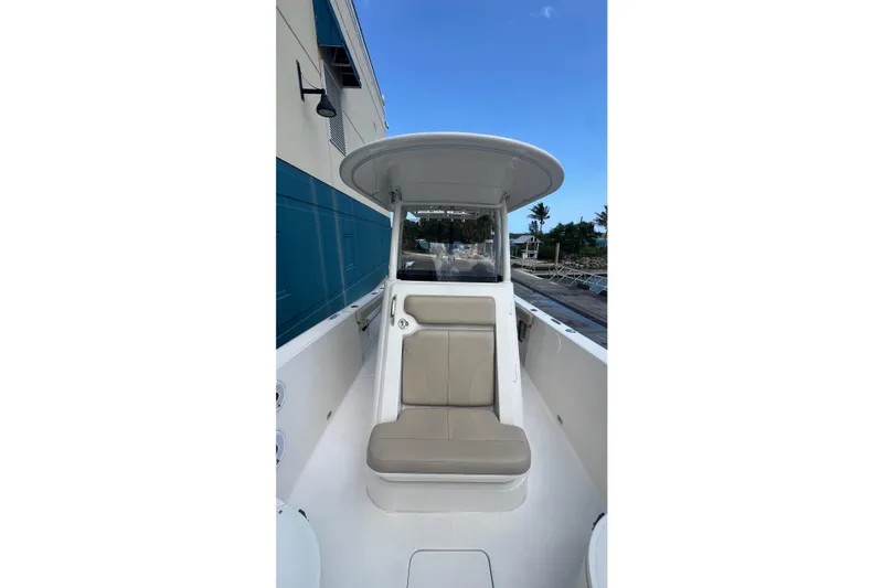 Slide: The Image of 2015 Pursuit C 260 Center Console boat with seating, docked near a building. - 7
