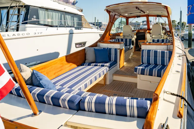 Slide: The Image of 2015 Hinckley Picnic Boat MK III with striped seating, docked at marina. - 11