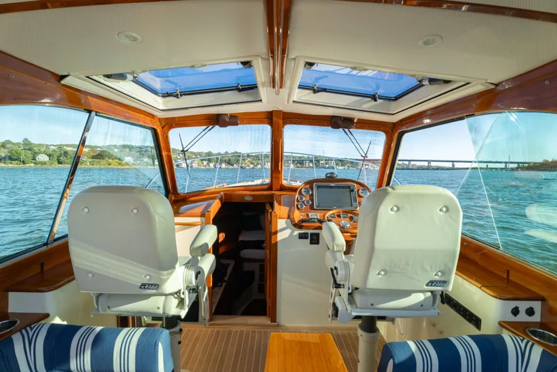Slide: The Image of Interior view of 2015 Hinckley Picnic Boat MK III, featuring helm and scenic waterway. - 17