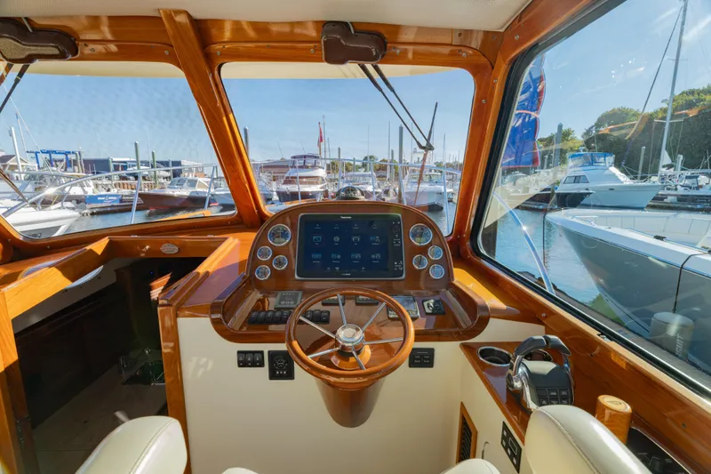 Slide: The Image of Interior of 2015 Hinckley Picnic Boat MK III with wooden dashboard and marina view. - 19