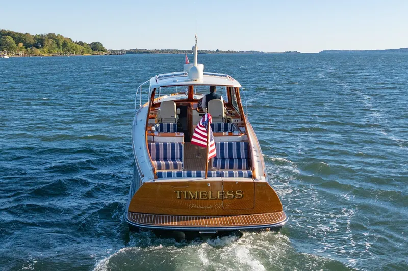 Slide: The Image of 2015 Hinckley Picnic Boat MK III cruising on open water, rear view. - 2