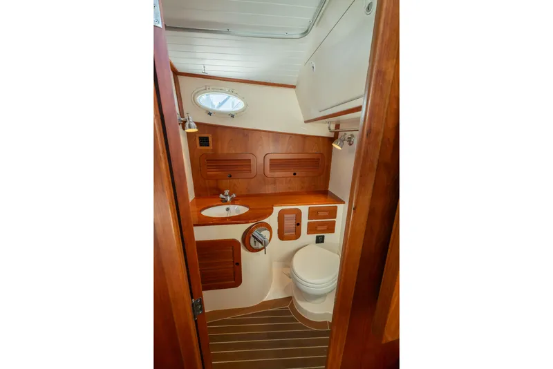 Slide: The Image of 2015 Hinckley Picnic Boat MK III bathroom with wooden cabinetry and compact design. - 26