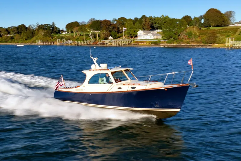 Slide: The Image of 2015 Hinckley Picnic Boat MK III cruising on a scenic waterway. - 3